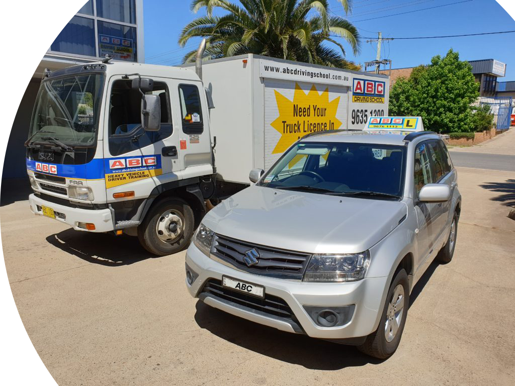 abc driving school car next to truck